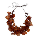 Adjustable necklace made with recycled fish scales in brown color, featuring waxed natural fibers and beads.