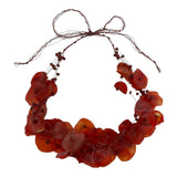 An adjustable necklace made with recycled fish scales in a brick/deep red color, featuring waxed natural fibers and beads.