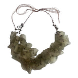 An adjustable necklace made with recycled fish scales in dark green/color, featuring waxed natural fibers and beads.